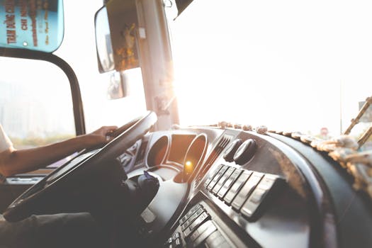 pexels-photo-977213-977213 A bus driver navigating the city streets during a sunny day, focusing on the road.